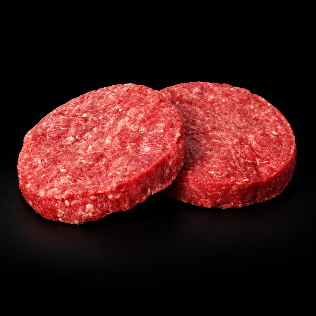 Hamburger di carne di scottona crudo su sfondo nero
